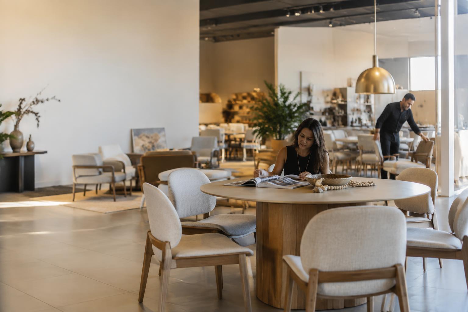 Profissionais analisando catálogo de móveis em showroom contemporâneo